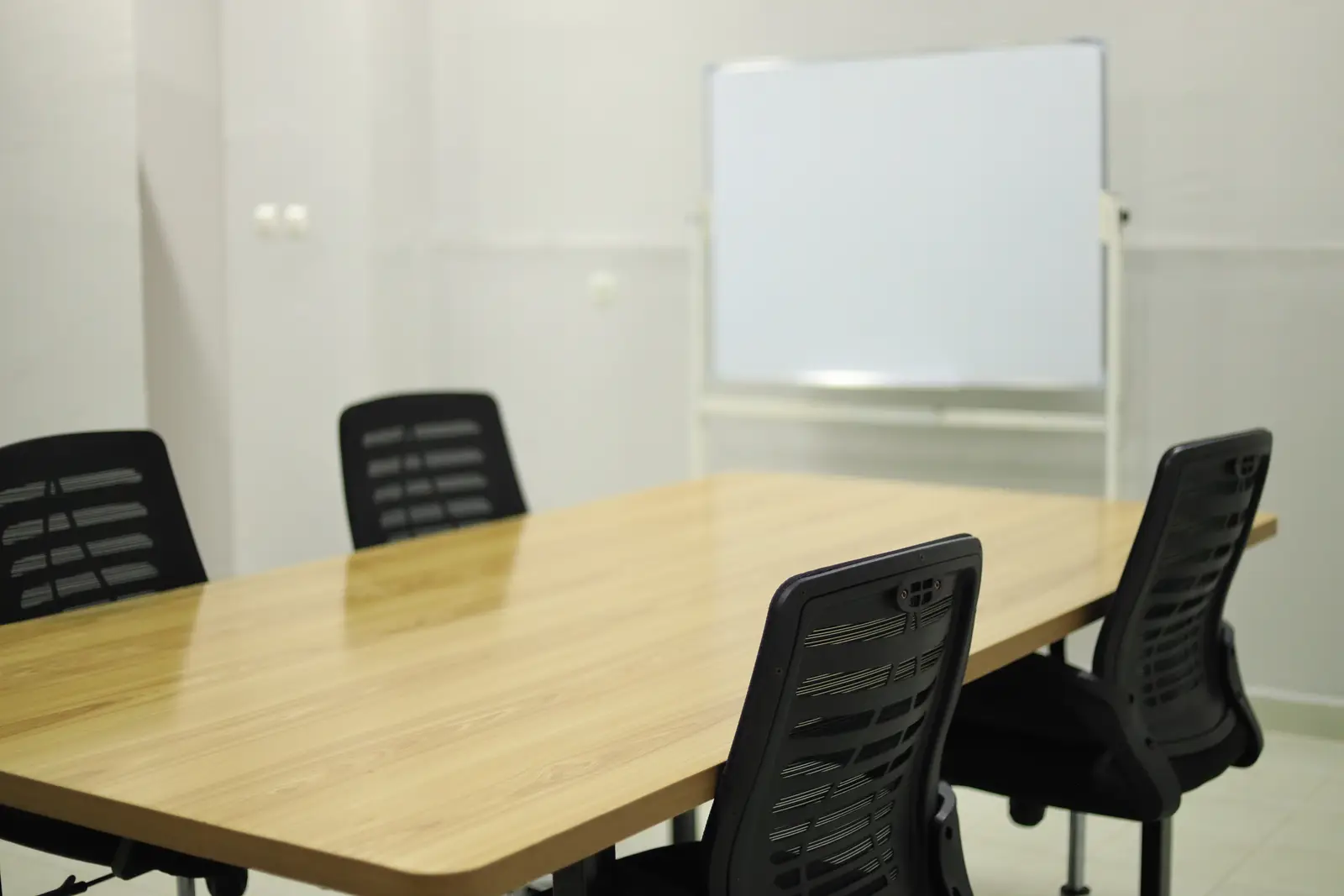The meeting room with chairs around the table and a whiteboard